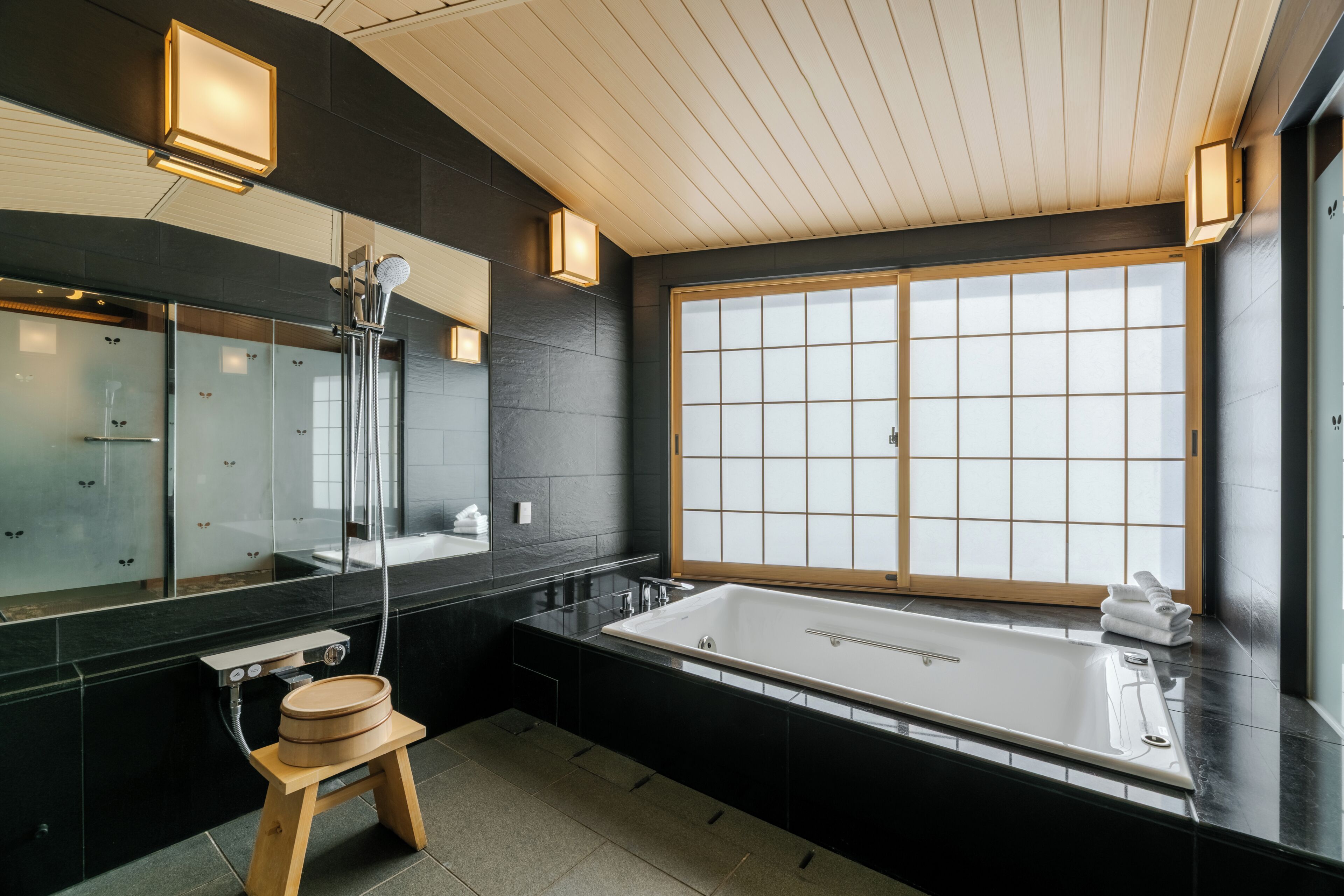 Un bagno moderno con una grande vasca da bagno, uno sgabello di legno e una grande finestra.