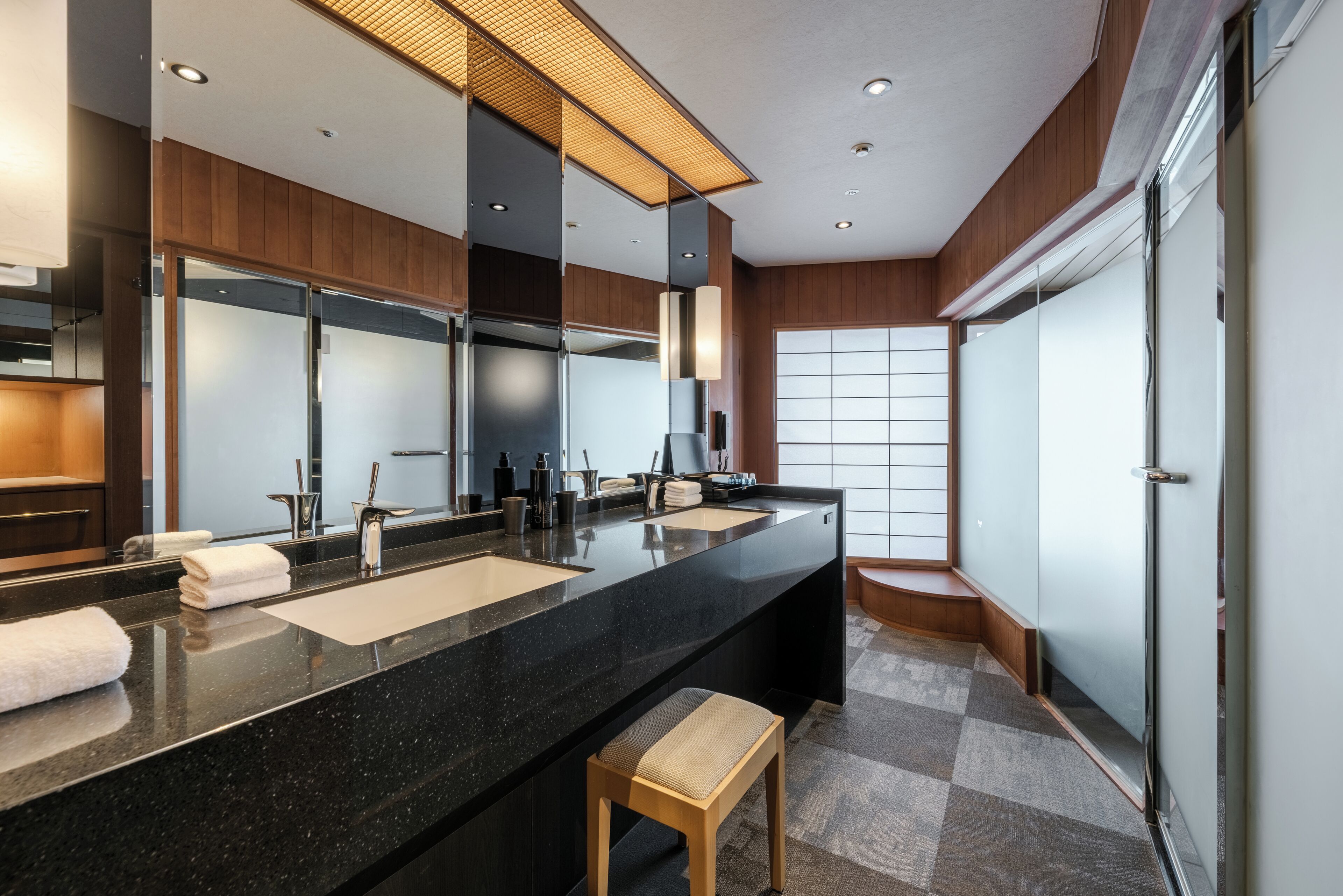 A modern bathroom with a large vanity, dual sinks, and a large mirror.