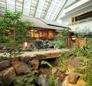 A traditional Japanese-style interior with a rock garden, bamboo bridge, and a koi pond. - Gajoen Tokyo (Tokyo)