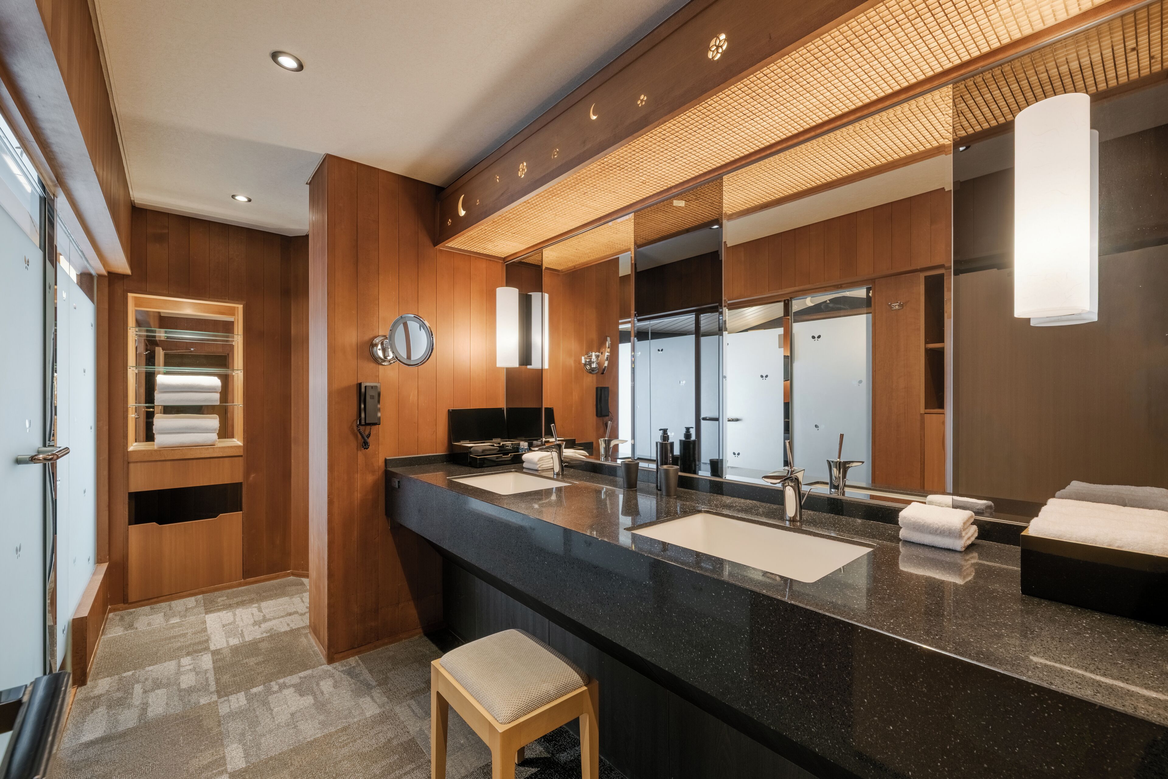 Un baño moderno con un espejo grande, dos lavamanos y un mueble de tocador de madera.