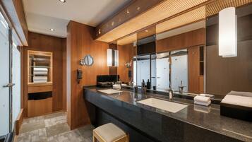 A modern bathroom with a large mirror, two sinks, and a wooden vanity.