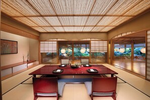A traditional Japanese-style room with tatami flooring, a low table, and shoji screens.