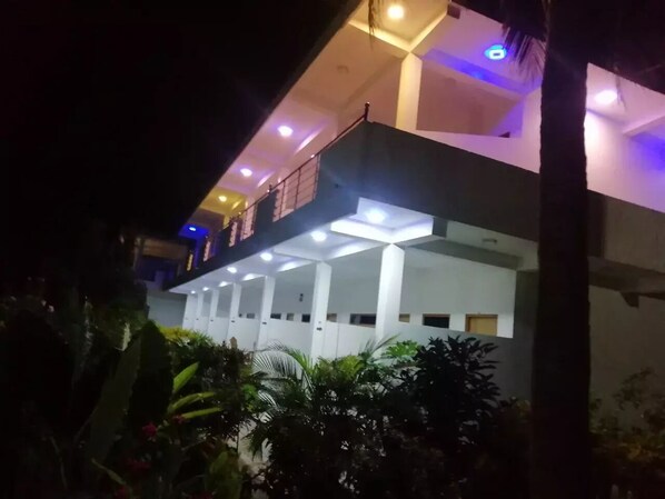 A multi-story building with a balcony and a covered outdoor area.