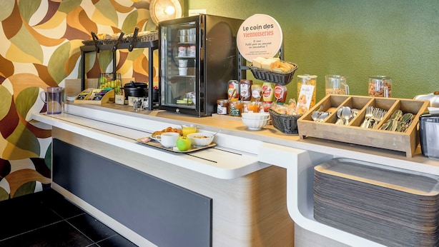 A breakfast bar with a refrigerator, coffee machine, and various food items. - B&B HOTEL Toulouse Cité de l'Espace Hurel (Toulouse)