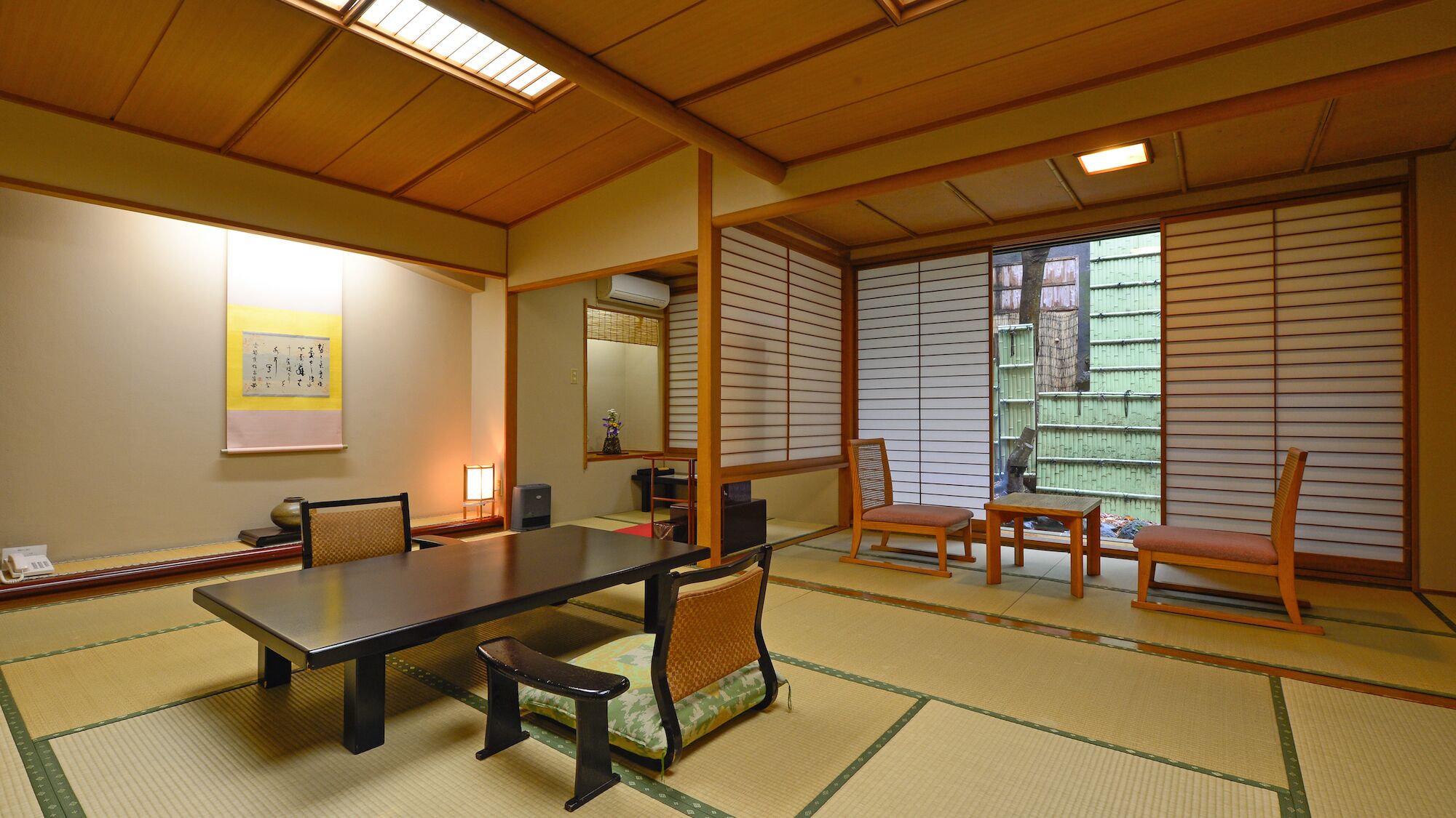 Una habitación japonesa tradicional con suelo de tatami, una mesa baja y puertas correderas.