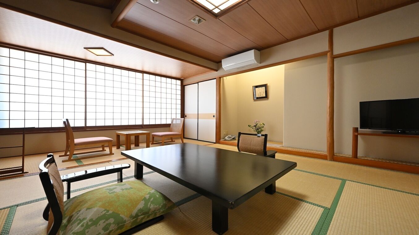 Een traditionele Japanse kamer met tatami vloerbedekking, een lage tafel en schuifdeuren.