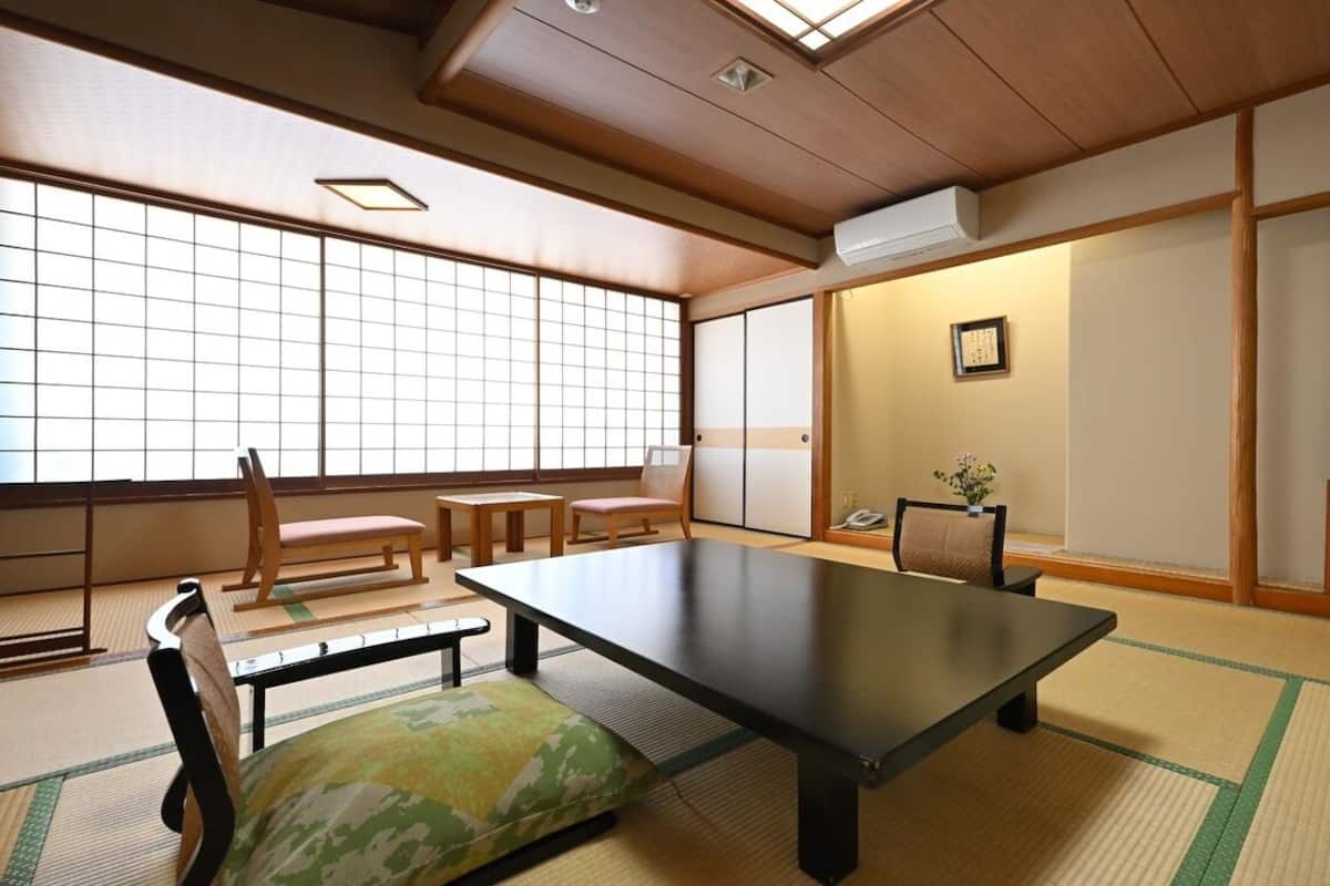 A traditional Japanese room with tatami flooring, a low table, and sliding doors.
