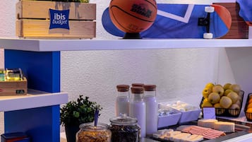 A buffet setup with various food items, a basketball, and a plant on display.