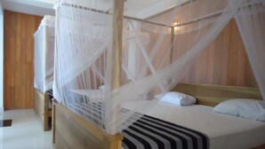 A bed with a canopy, wooden headboard, and striped bedding.