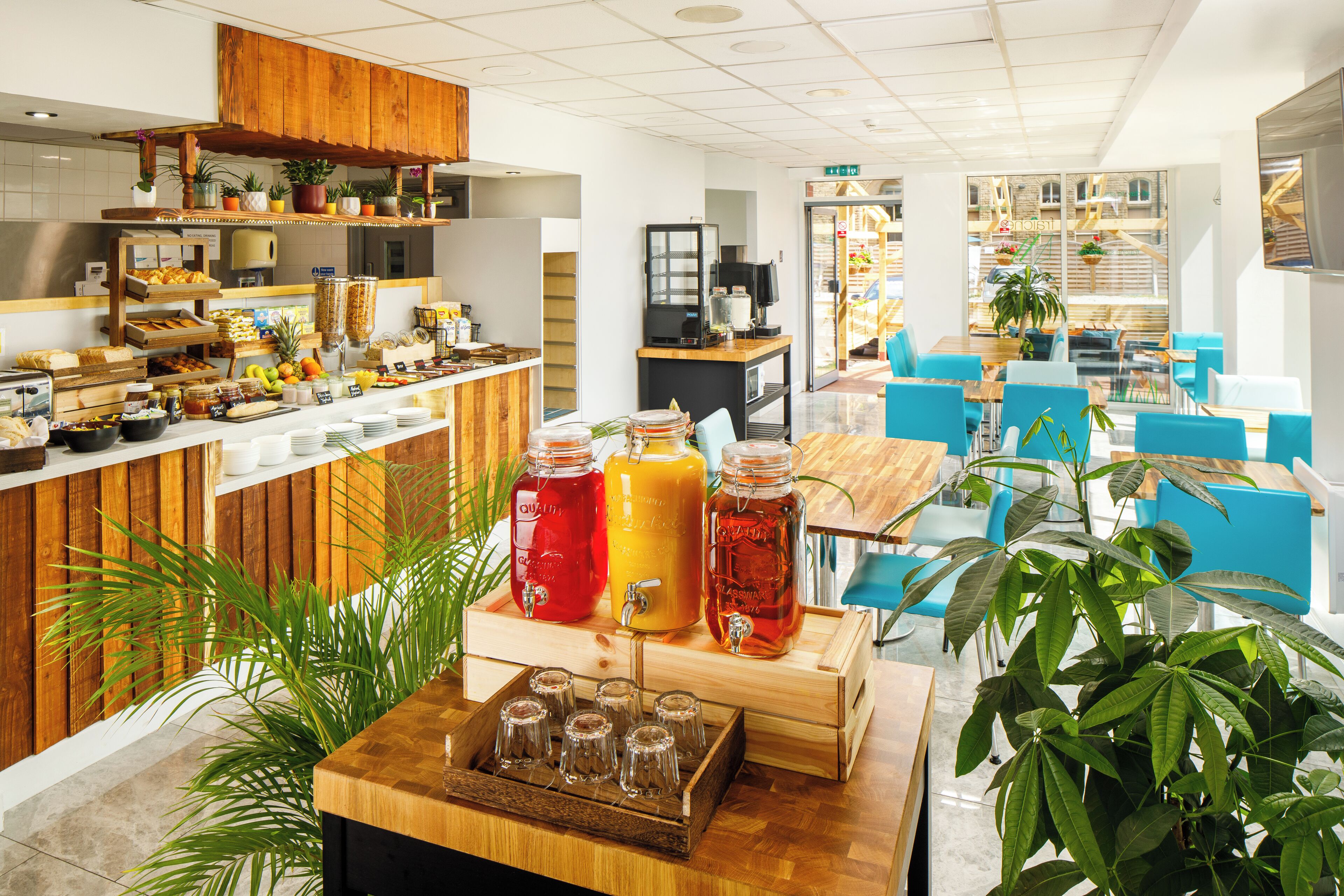 A modern cafe with wooden accents, a variety of food and drink options, and comfortable seating areas.