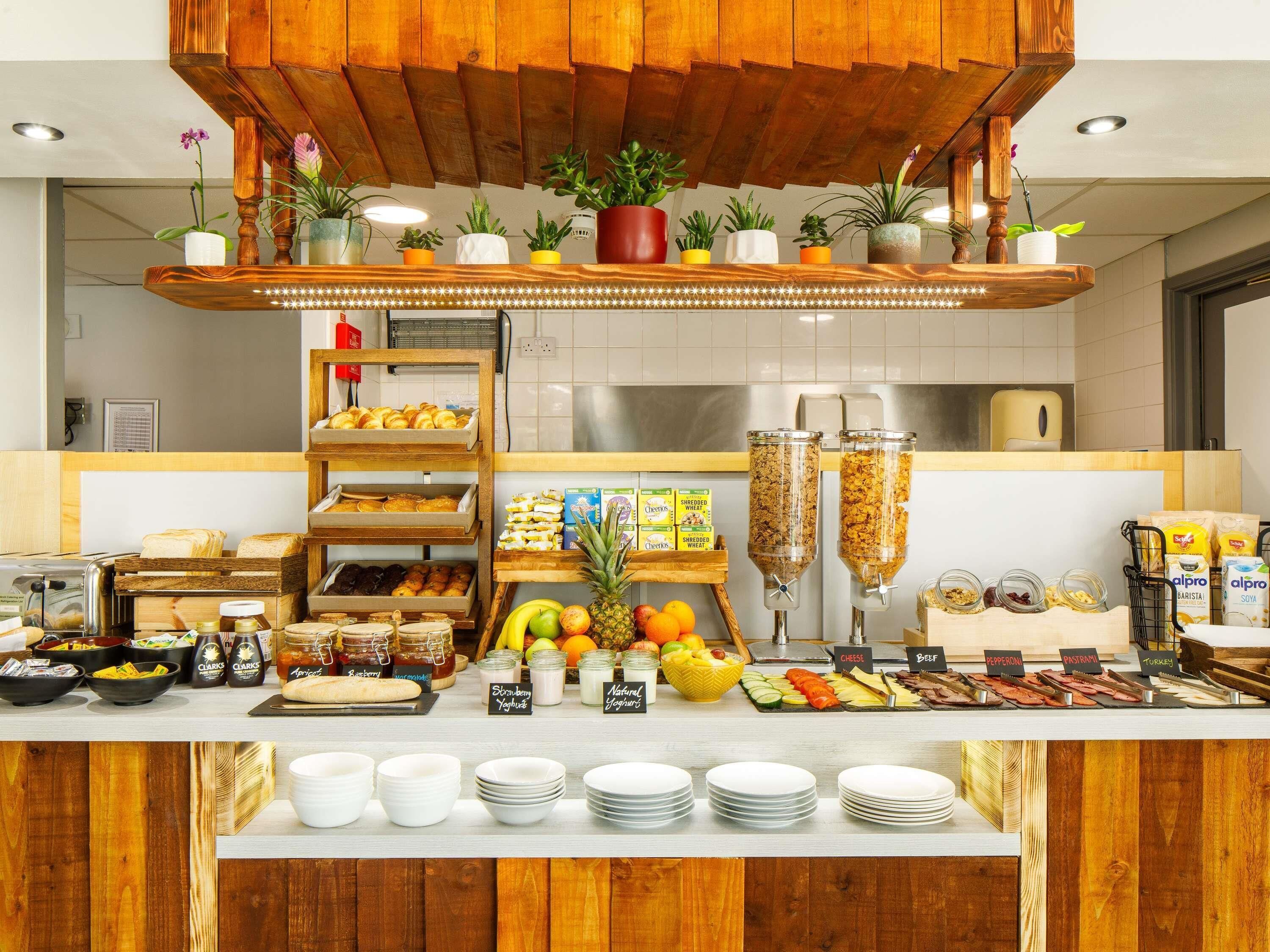 A breakfast buffet with various food items, including fruits, cereals, and dairy products.
