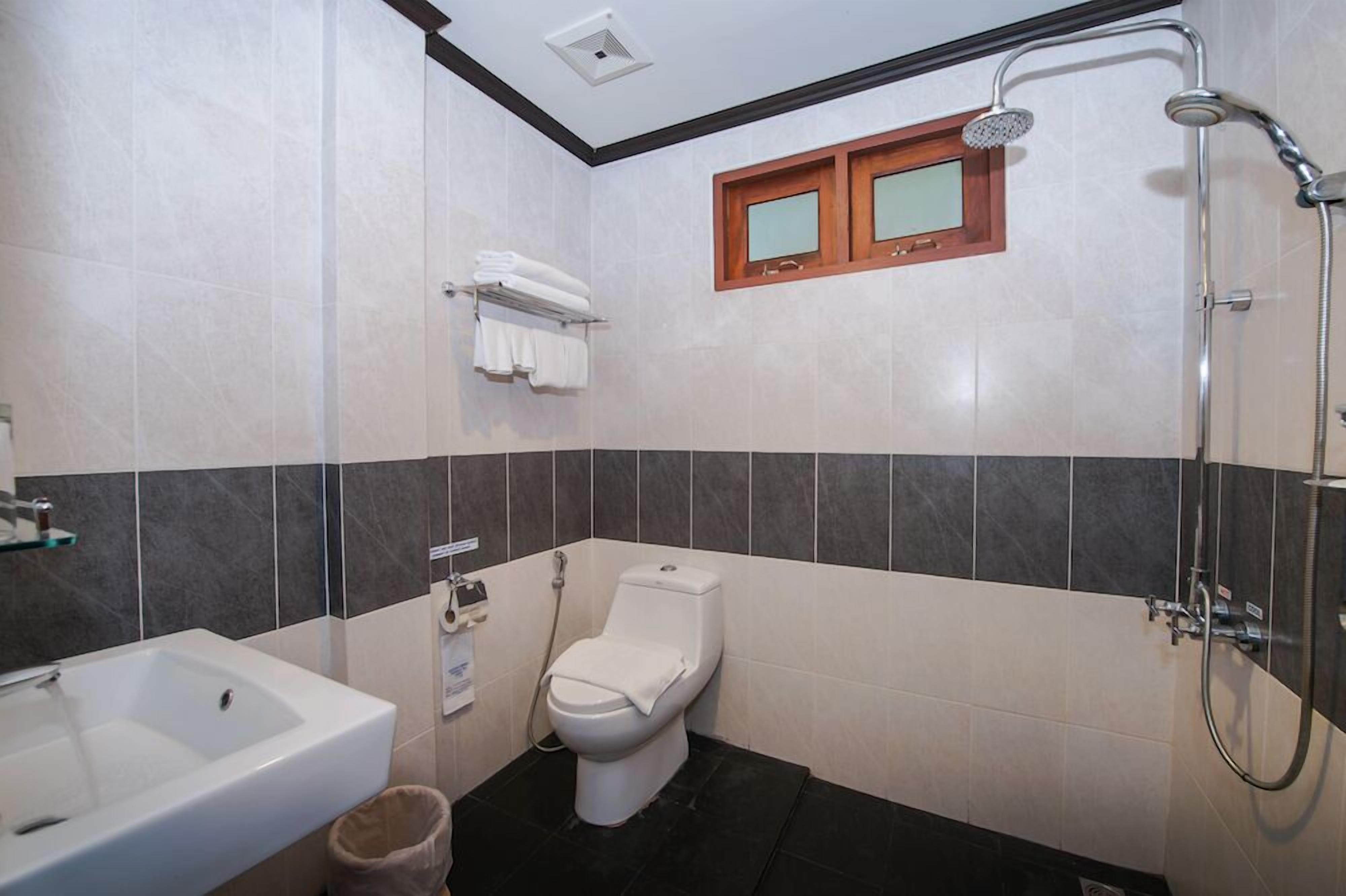 Un baño con inodoro, lavamanos y ducha.