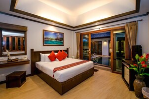 Habitación de hotel con una cama grande, un escritorio con ordenador, una ventana con cortinas y vistas al exterior.