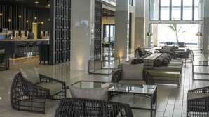Un vestíbulo amplio con zona de bar, disposición de asientos y grandes ventanales con vistas.