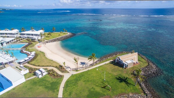 An aerial view of a resort with a beach, clear blue waters, and a pool area. - Taumeasina Island Resort (Apia)
