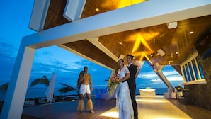 Una ceremonia de boda en una terraza de madera con vista al océano.