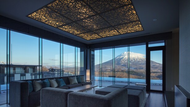 A modern living room with a large window offering a view of a mountain.