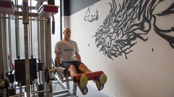 Ein Fitnessstudio mit Trainingsgeräten und einer großen Wandmalerei.