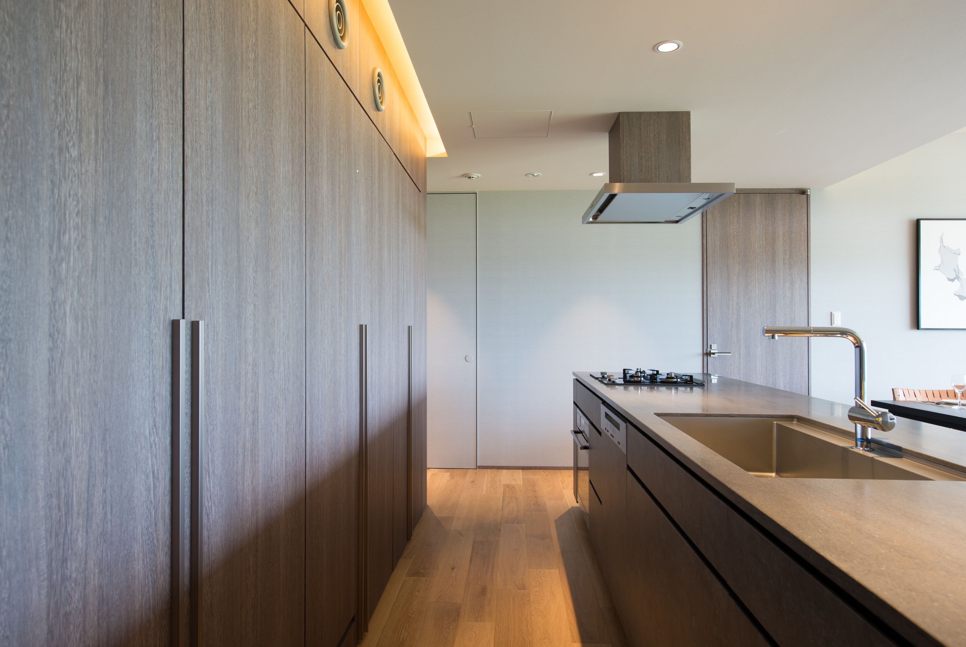 A modern kitchen with wooden cabinets, a stainless steel sink, and a built-in oven.