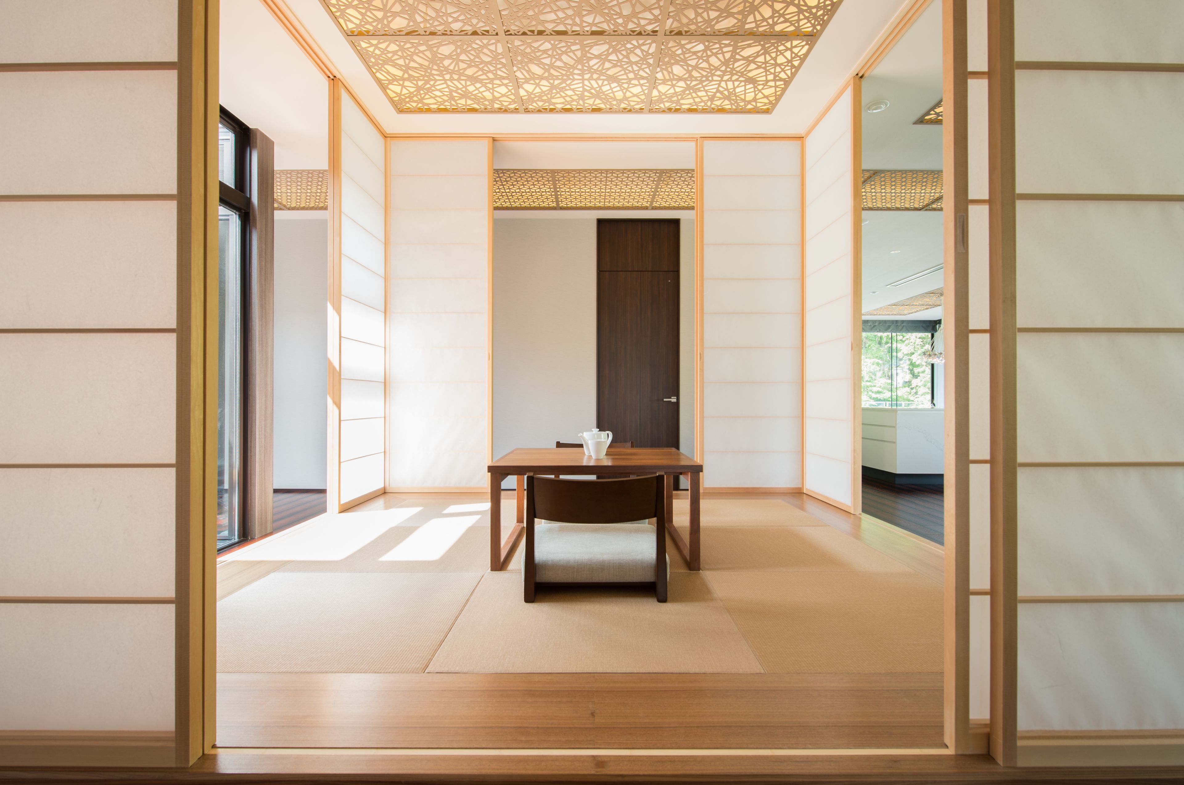 A traditional Japanese room with tatami flooring, a low wooden table, and sliding doors.