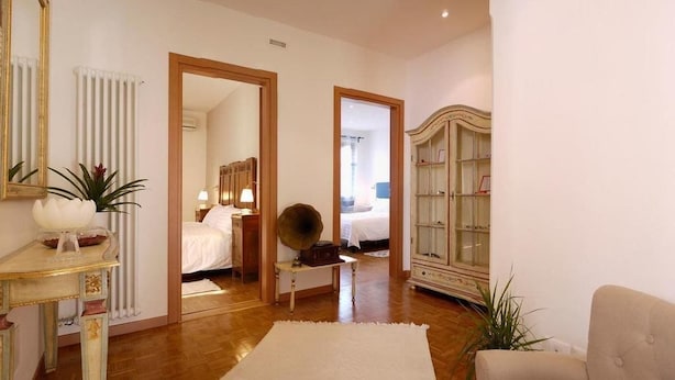 Una habitación con cama, tocador, espejo y radiador.