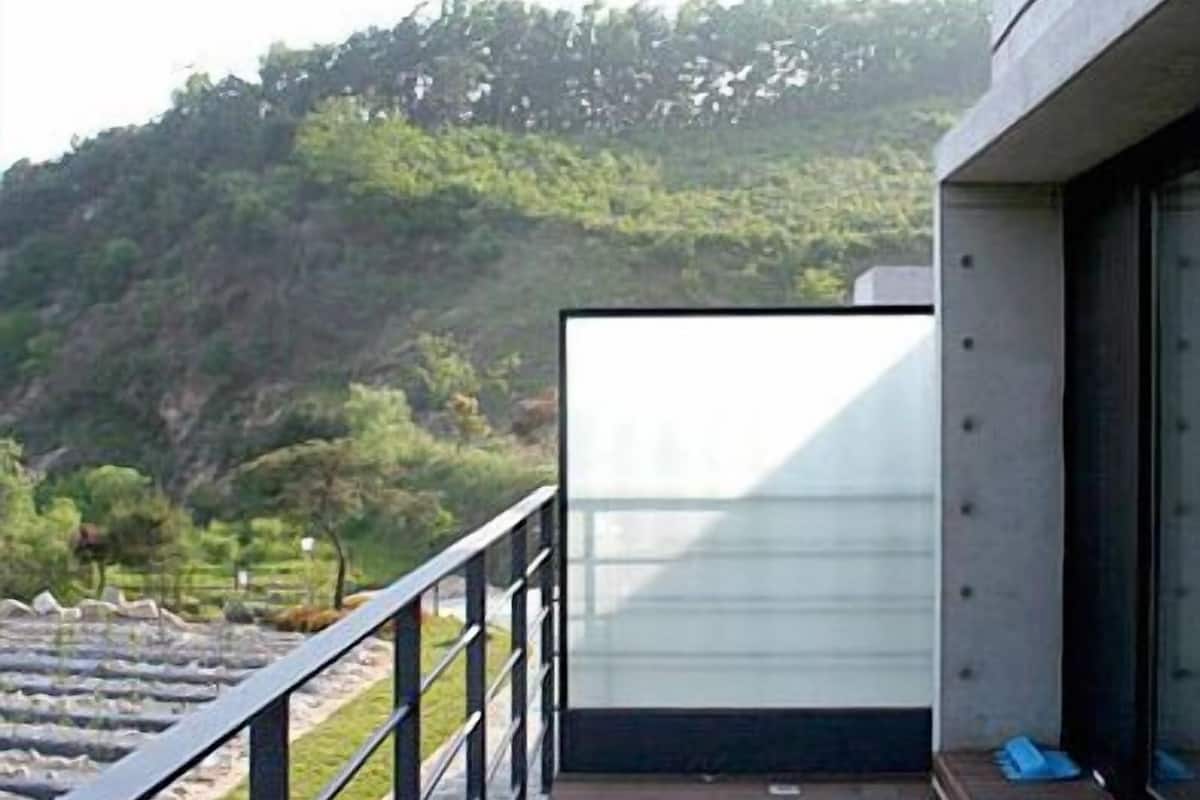 A balcony with a view of a hillside.