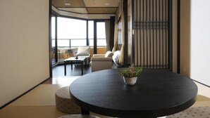 A modern interior with a round table, two chairs, and a potted plant. - Saiounomiya (Ise)