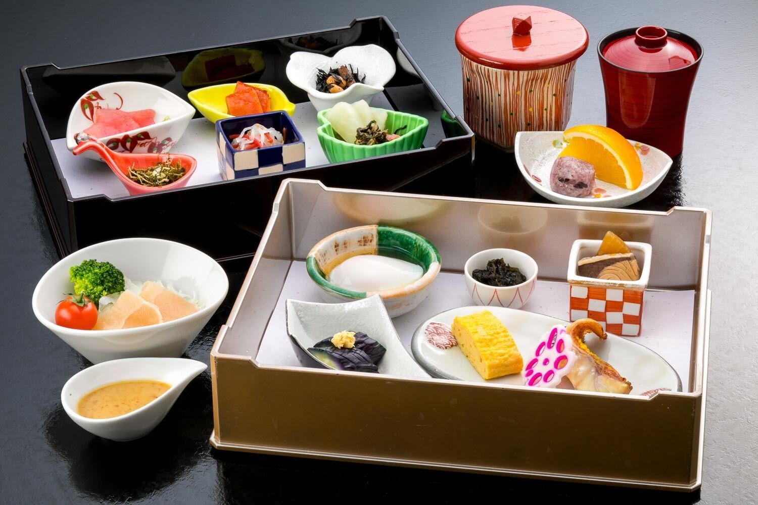 A traditional Japanese bento box with various food items and small dishes.