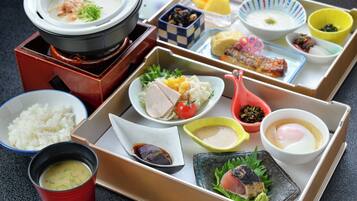 Variedad de platos japoneses dispuestos en una mesa, incluyendo arroz, sopa y sashimi.