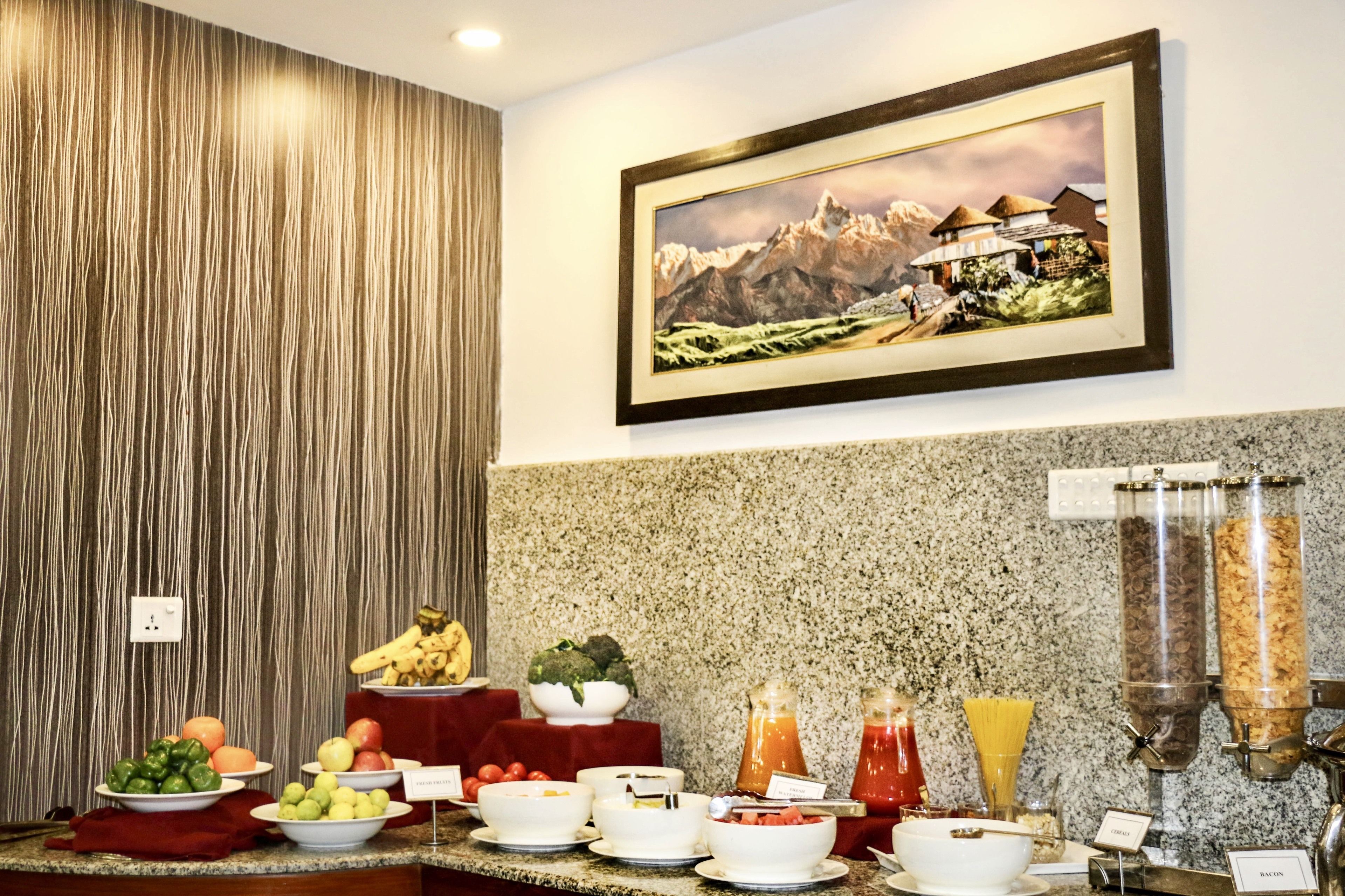 A breakfast buffet with various fruits, vegetables, and beverages.