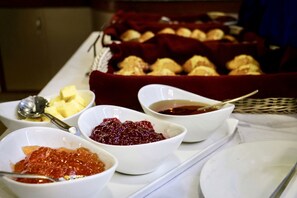 A buffet table with various food items including bowls of jam and butter, and a basket of pastries. - Hotel Arts Kathmandu (Kathmandu)