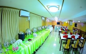 A banquet hall with long tables covered in green tablecloths, arranged in rows. - Vega Star Hotel (Yangon)