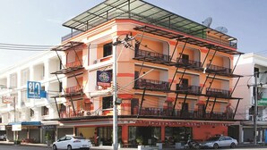 A multi-story building with balconies, a pharmacy sign, and parked cars. - Krabi Orchid Hometel (Krabi)