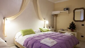 A bedroom with a bed, a nightstand, a mirror, a small Christmas tree, and a radio. - Botton d'Oro Pelabrocco (Bergamo)
