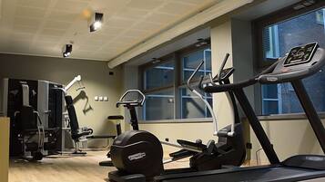 Uma academia com esteiras, elípticos e equipamentos de musculação.