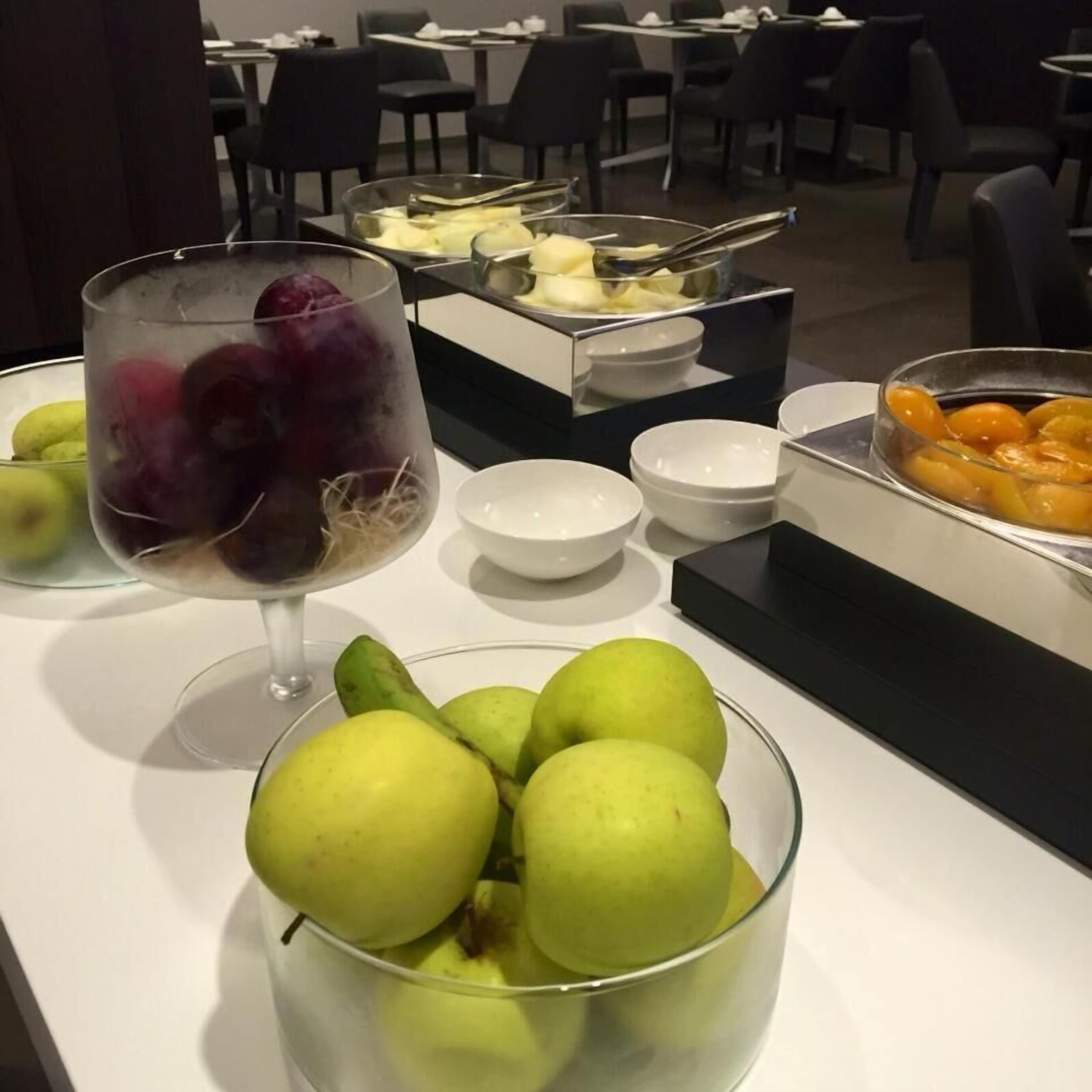 Una mesa de buffet con varias frutas y cuencos.