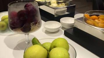 Una mesa de buffet con varias frutas y cuencos.
