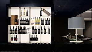 Eine Bar mit Weinauslage und Sitzgelegenheiten.