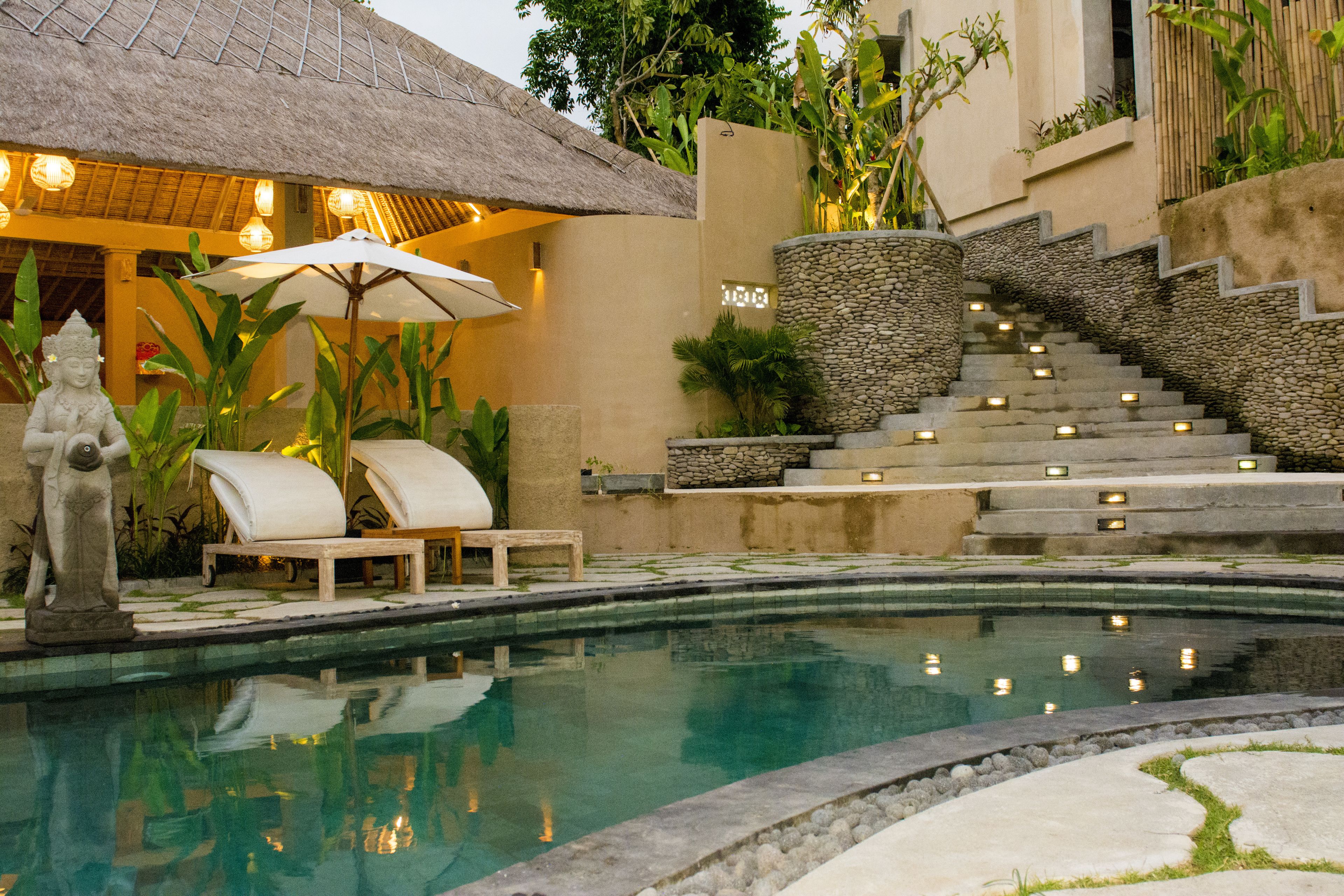 Una piscina al aire libre, sillones reclinables de piscina