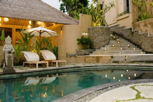 Una piscina al aire libre, sillones reclinables de piscina