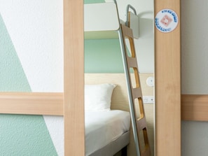 A bunk bed with a ladder, a pillow, and a wall socket. - ibis budget Toulouse Blagnac Aéroport (Blagnac)