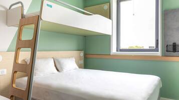 A bunk bed with a ladder, a window with a view, and a bedside table.