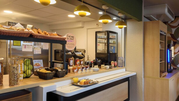 A breakfast buffet area with various food items and condiments.
