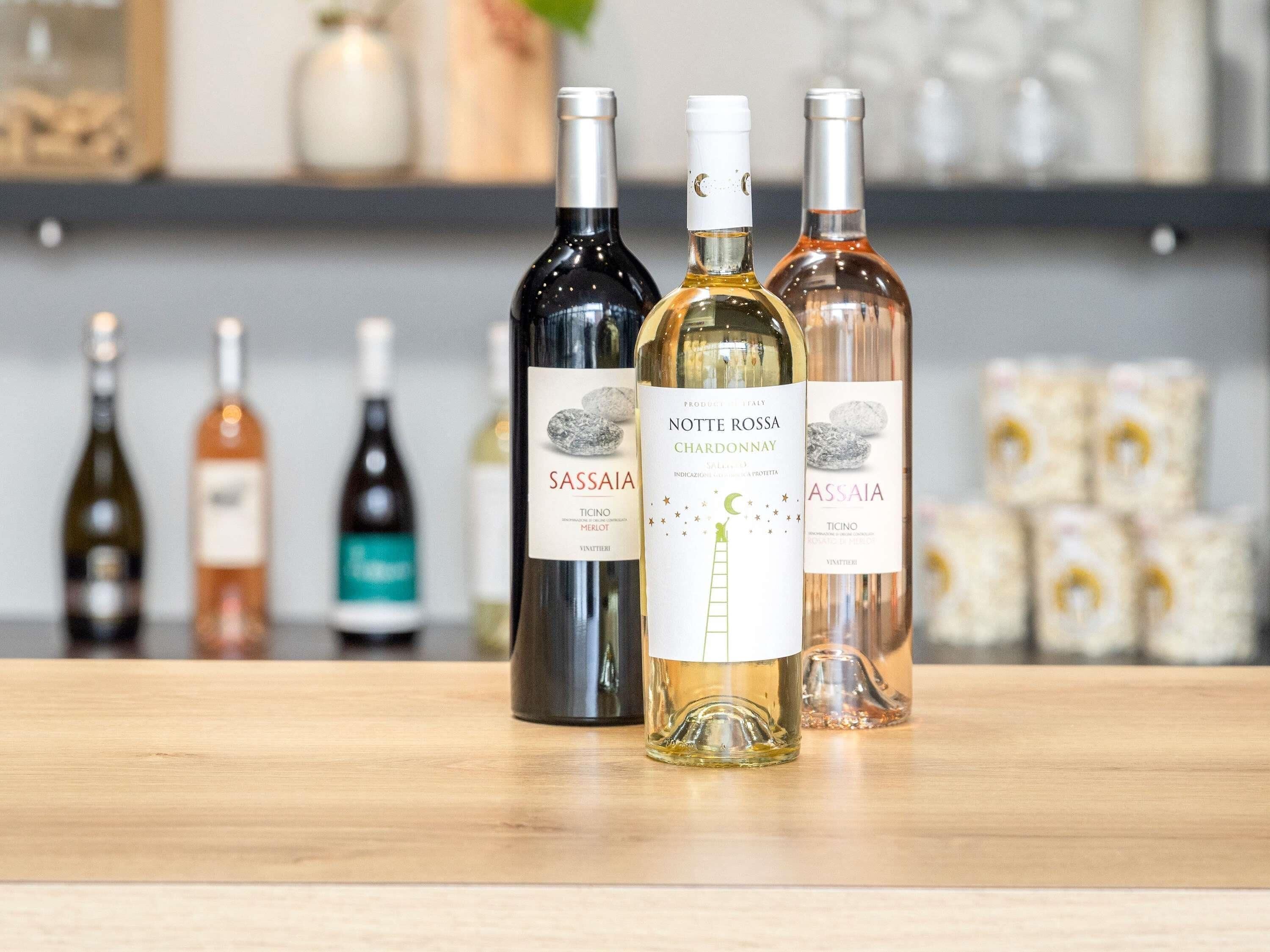 Varias botellas de vino sobre una superficie de madera, con un fondo desenfocado.