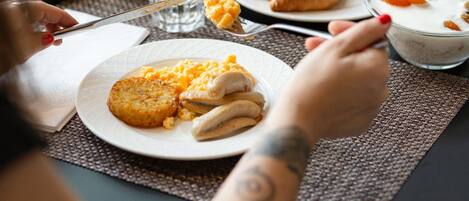 Desayuno con platos de comida, un vaso de jugo de naranja y una taza de café.