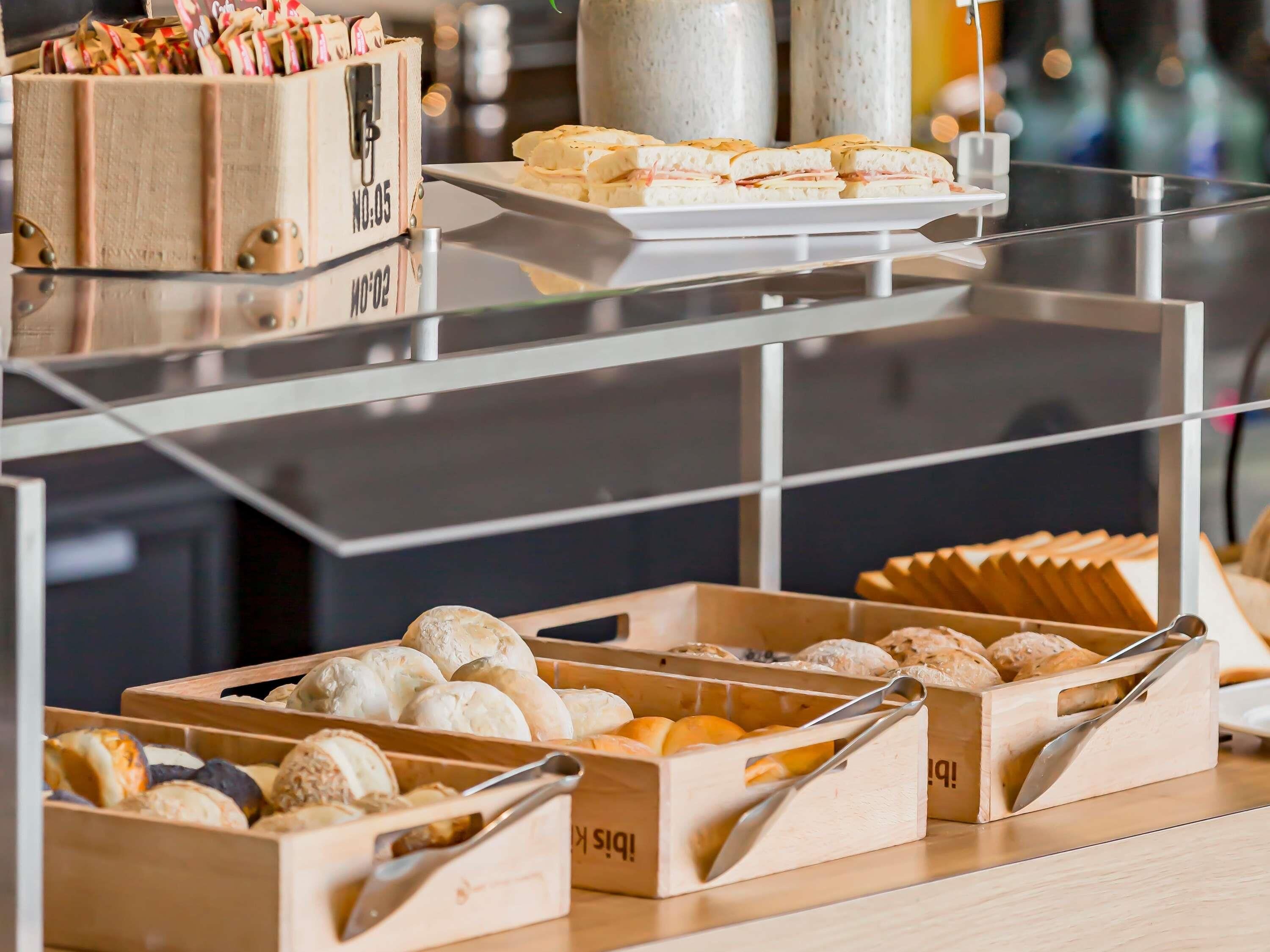 Una vitrina con diversas opciones de panadería, incluyendo pan y pasteles, en cajas de madera.