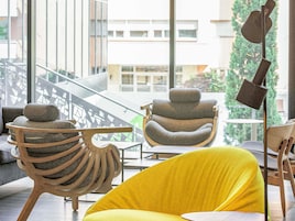 Un interior moderno con un sofá amarillo, una silla de madera de diseño único y una lámpara de metal.