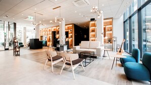 Eine moderne Lobby mit Sitzgelegenheit, einem Klavier und einem großen Fenster.