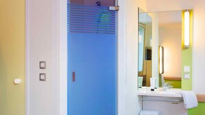Un baño con puerta de ducha azul, un lavabo con espejo y un perchero para toallas.