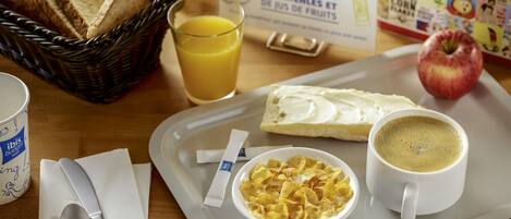 A breakfast tray with toast, cereal, coffee, and a glass of orange juice.